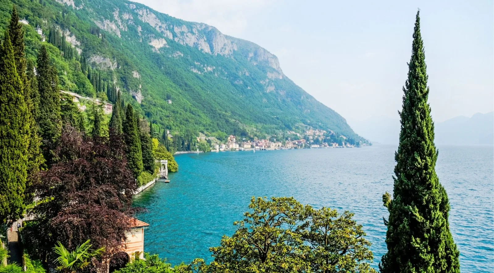 The terraced garden walk at Villa Monastero, cypresses rising above the path as Lake Como opens northward