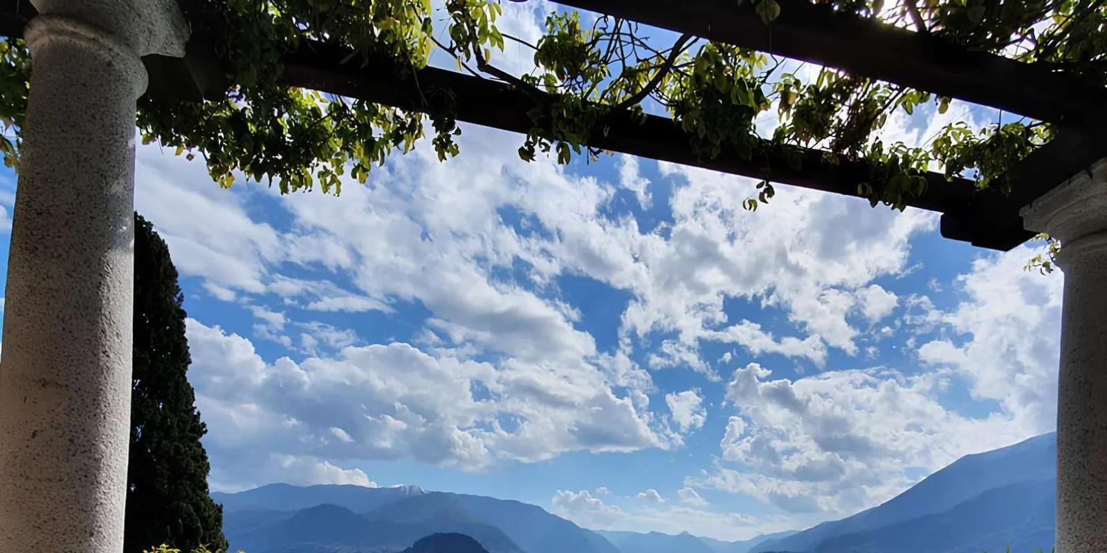 Looking out from under the Villa Cipressi pergola to cloud over the Lake Como mountains
