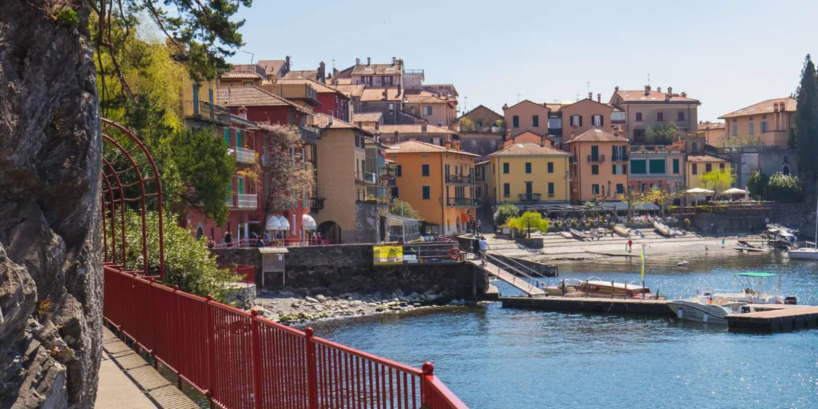 The red-railed lakeside walkway into Varenna, with the harbour and pastel houses beyond