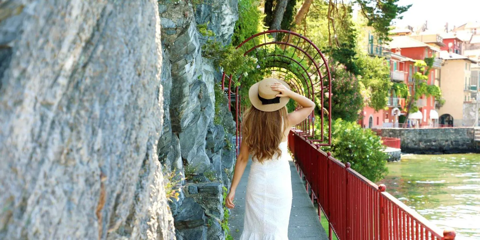 Walking Varenna's Passeggiata degli Innamorati under its red iron arches beside the water
