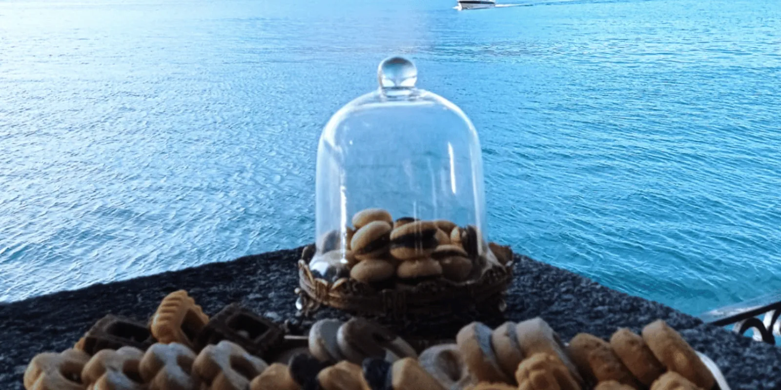 Aperitif biscuits under a glass cloche on a table above Lake Como at Villa Monastero