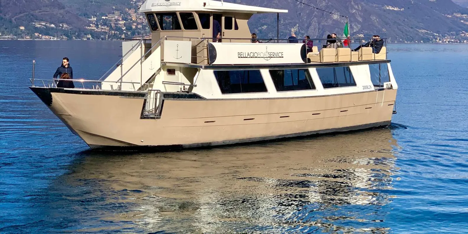 The Bellagio Boat Service cruiser under way on Lake Como, passengers on the open upper deck
