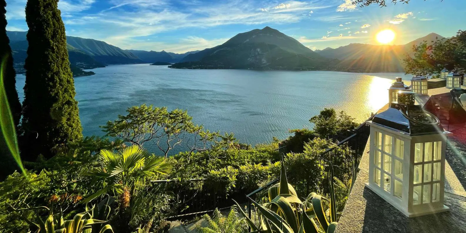Sunset over Lake Como from a Varenna terrace, lanterns and agaves in the foreground